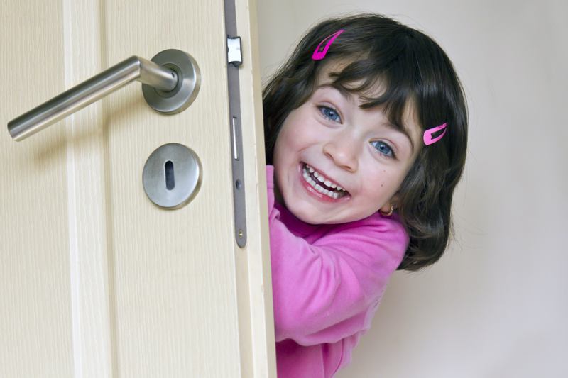 Smiling child behind a door