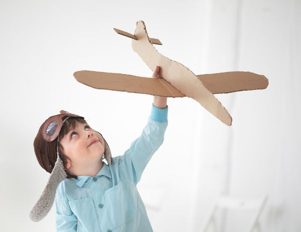 Boy playing with cardboard plane