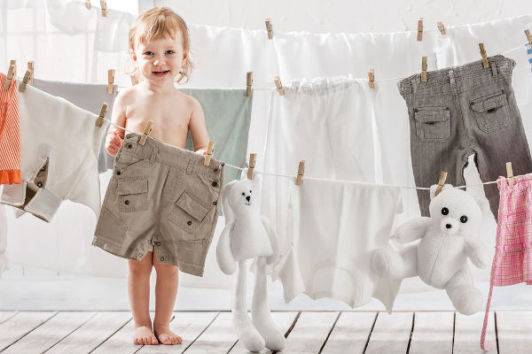 Little girl hangs laundry