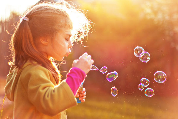 girl blowing soap bubbles