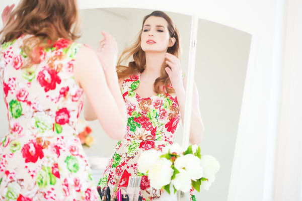woman in floral dress by mirror
