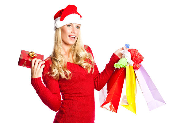 A portrait of a beautiful caucasian christmas santa girl carrying shopping bags
