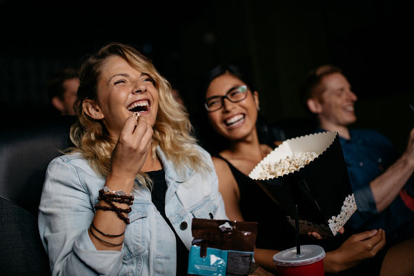 Young woman with friends watching movie in cinema
