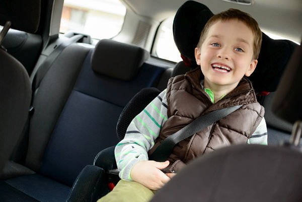 Happy little boy in car safety seat. Children car safety concept