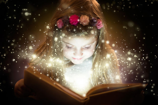 Little girl reading magic book, fantasy concept