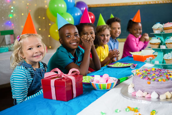 Portrait of children sitting at table during birthday party