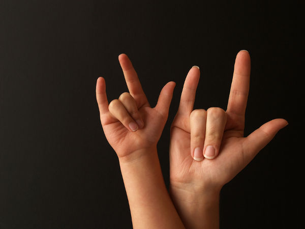 a mother and her child doing sign language for I LOVE YOU