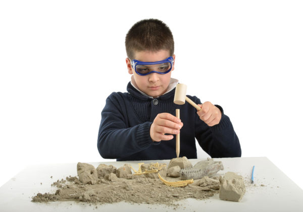 Child using tools at an archeology dig site