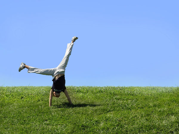 girl doing cartwheel on the grass