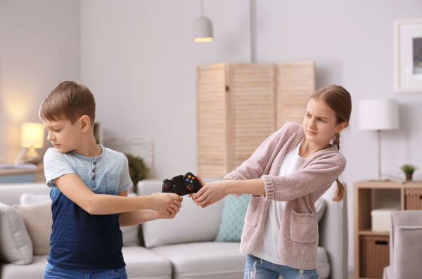 Brother arguing with sister at home in living room