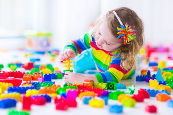 Little Girl Playing With Colorful Toy Blocks