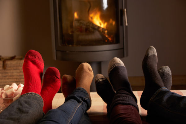 Familys Feet Relaxing By Cosy Log Fire 