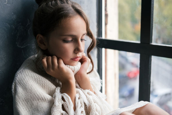 Pensive Girl With Sad Emotions Sitting On Sill,