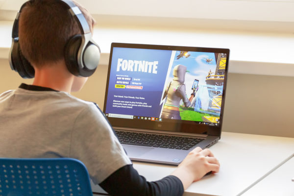 Boy playing Fortnite on a laptop