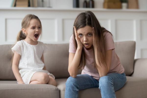 young girl screaming at a stressed mother