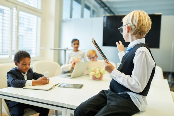 Children dressed in business attire having a meeting