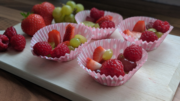 Chopped strawberries, grapes and raspberries in muffin cases