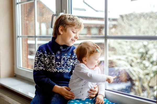 Children looking out of the window in winter