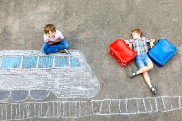 Two boys with suitcases and chalk train drawing