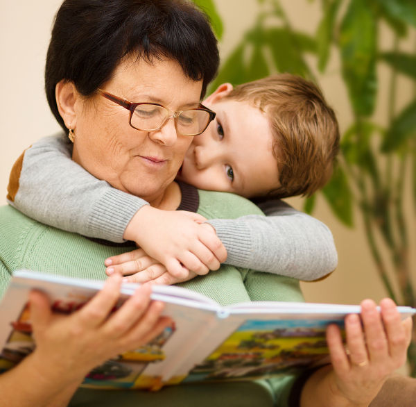 Grandmother is reading book with her grandson