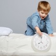 Little boy in bed with clock