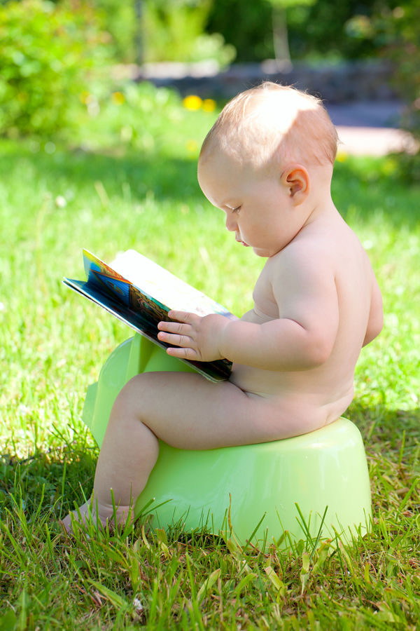 Outdoors on potty with book