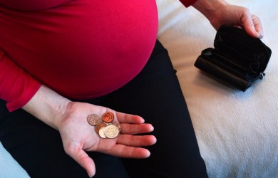 Pregnant woman with small money and empty wallet