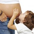 Young boy is kissing the pregnant woman