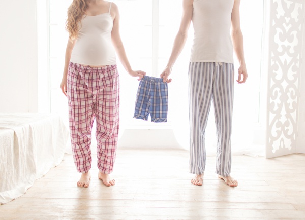 pregnant couple holding children's pajamas