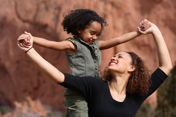 Mother and child playing outdoor holding hands