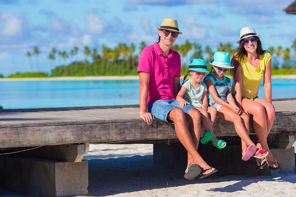 Beautiful family of four on beach during summer vacation
