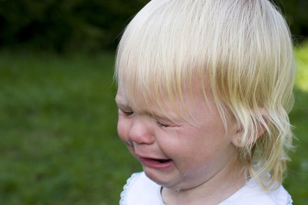 Blond child screaming with tears