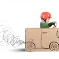 Creative baby plays with his cardboard car