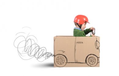 Creative baby plays with his cardboard car