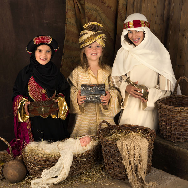 Teenager girls playing a live Christmas nativity scene (the baby is a doll)