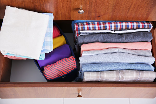Neatly folded clothes in wooden drawer