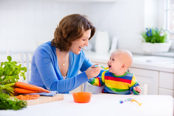 Mother feeding child healthy vegetables