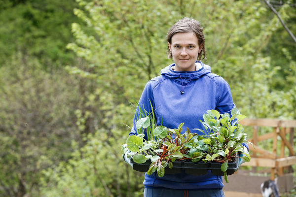 Proud and happy woman gardener bringing her homegrown seedlings