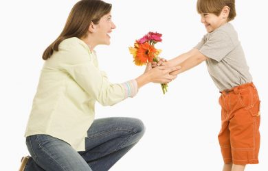 Son giving bouquet of flowers to mother.