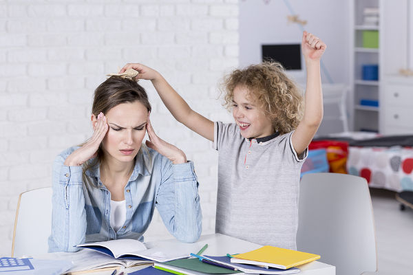 Child annoying his tired mother with headache