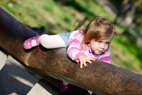 funny toddler girl climbing on the walk
