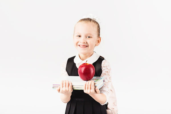 Girl with backpack, books, and apple