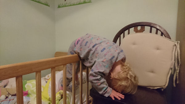 Baby climbing out of cot