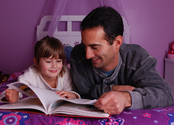 A father and daughter spend time reading a book