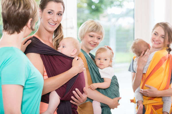 Group of women learning how to use baby slings for mother-child bonding