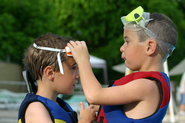 older brother helping younger brother get ready to swim