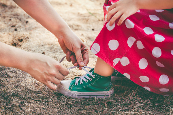 mother-helping-daughter-to-tie-shoes