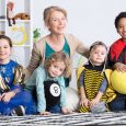 Dressed up children in colorful costumes and happy kindergarten teacher