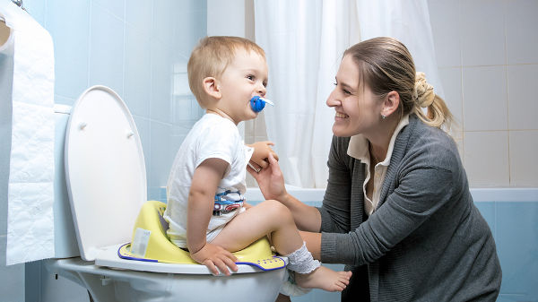 Young mother smiling after her toddler son used toilet