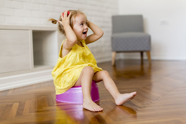 Little girl on the potty in the room